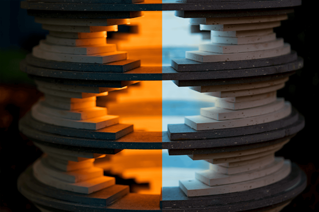 Close-up of the sculpture, with a dramatic split down the middle of the image. On the left, a warm orange light emanates from inside out. On the right, cool blue light seeps from inside the sculpture.